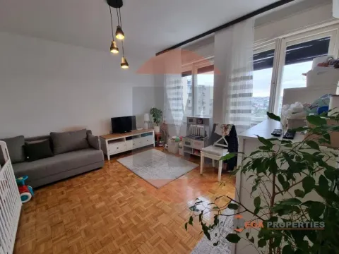 Living room with a sofa, TV unit, and parquet flooring. - image 3