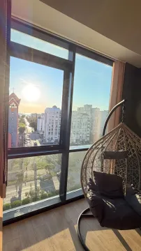 Pogled iz stanova na grad i ulicu sa visećom foteljom uz prozor. - image 19