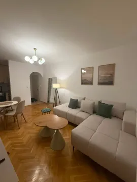 Spacious and bright living room with a sectional sofa and dining area. - image 2