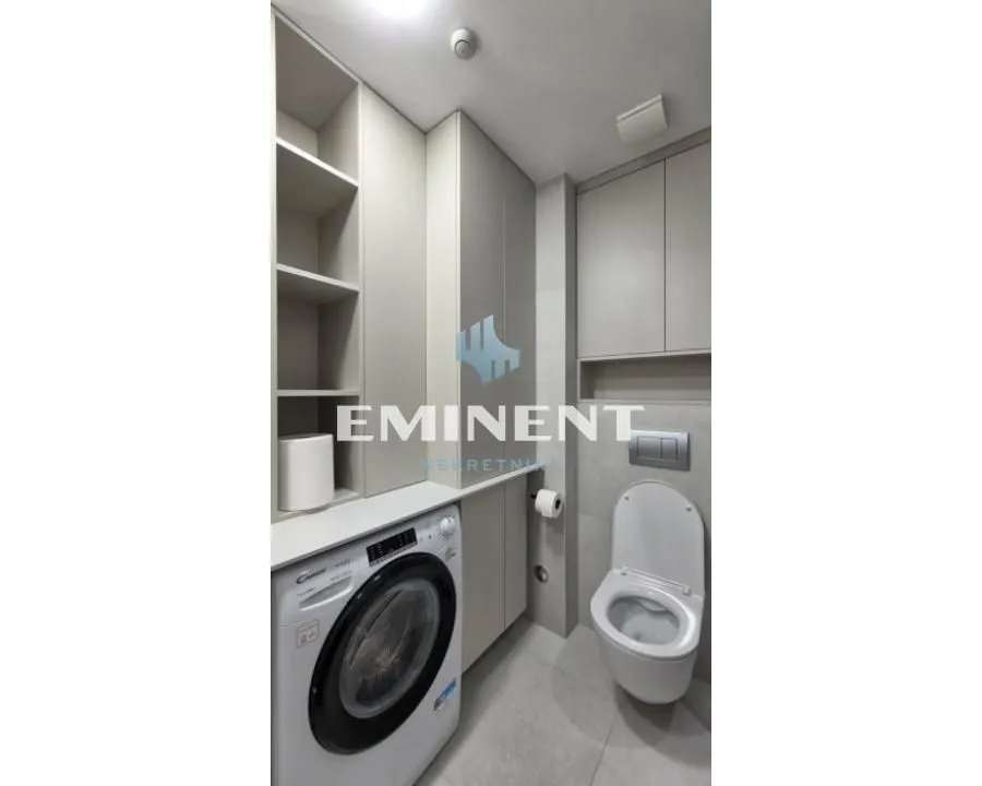 Modernly equipped bathroom with a washing machine and built-in units.