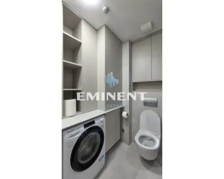 Modernly equipped bathroom with a washing machine and built-in units. - image 10