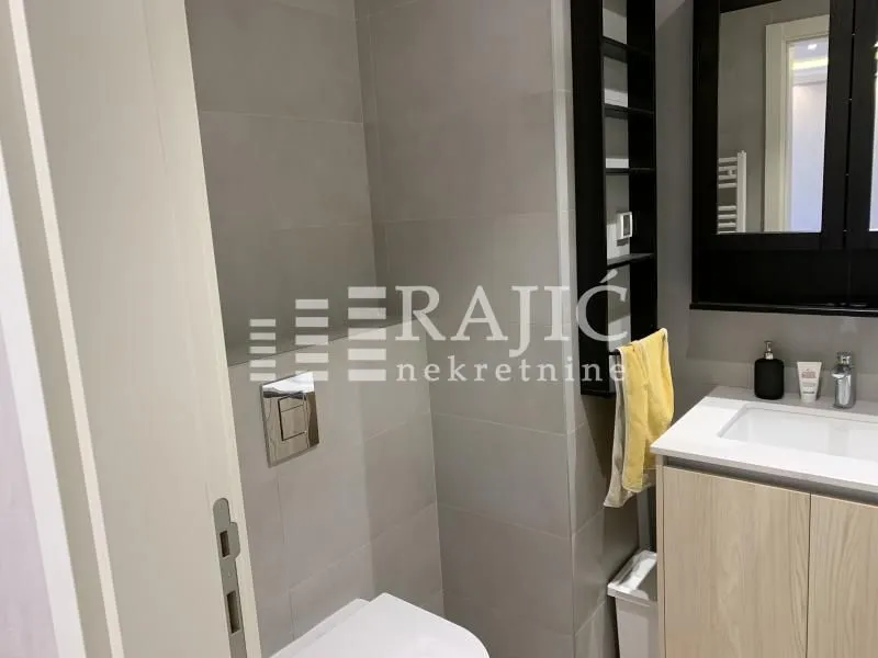 Modernly equipped bathroom with a washbasin and toilet.