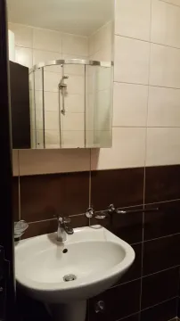 A simple bathroom featuring a white sink and a mirror. - image 15