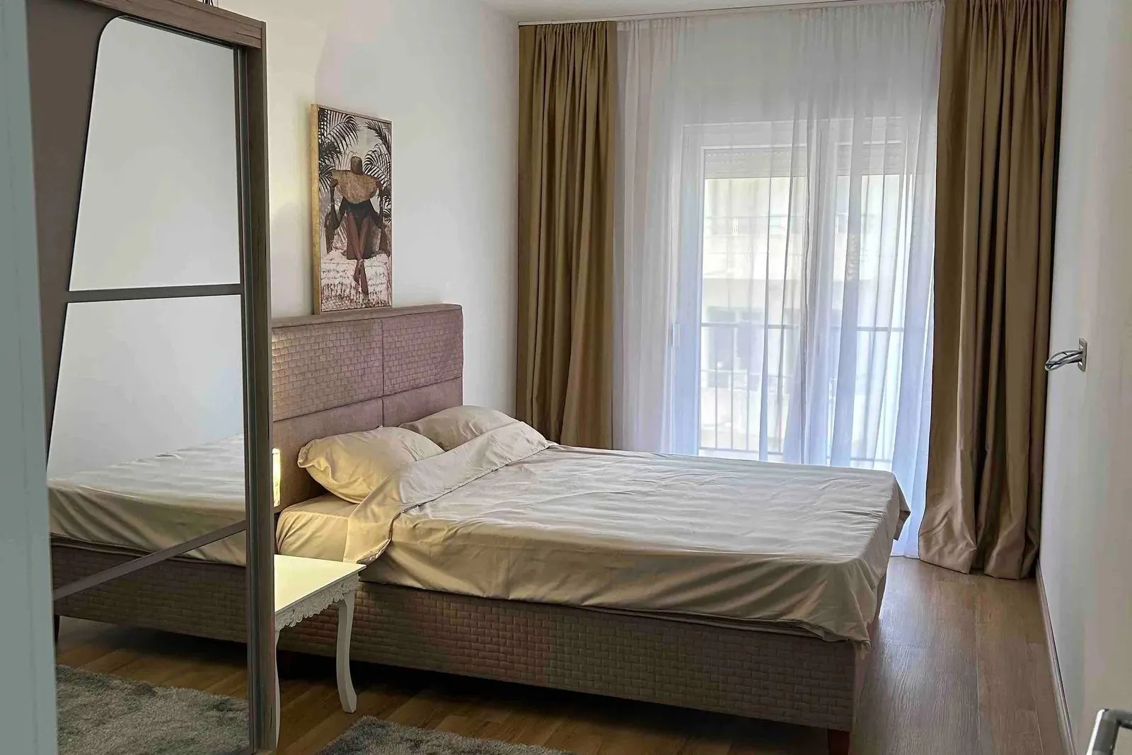 Spavaća soba sa bračnim krevetom, garderoberom sa ogledalom i izlazom na terasu.