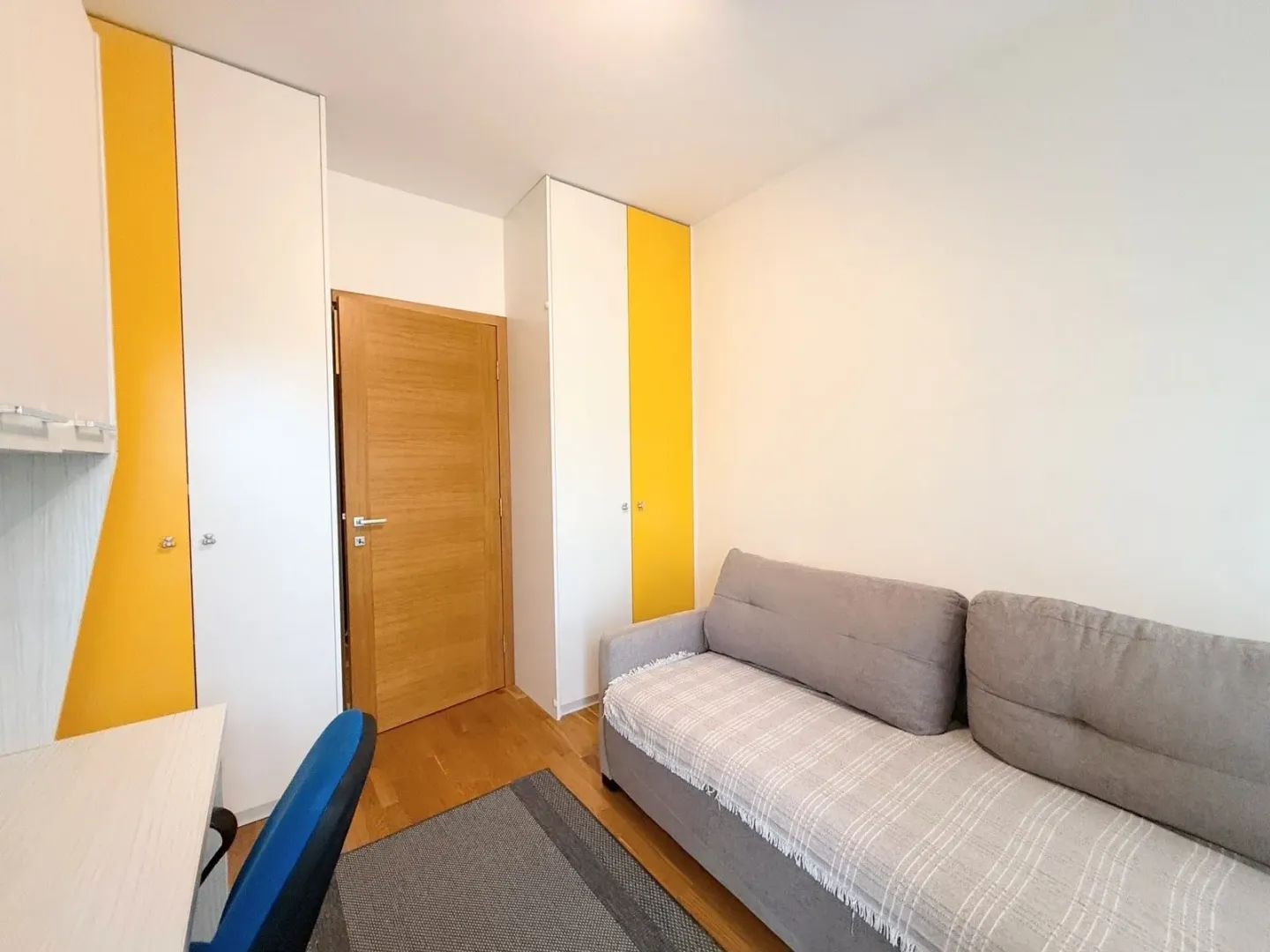 Smaller bedroom with a bed, wardrobes, and a desk.