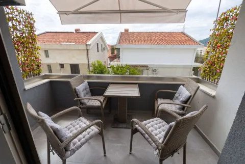 Furnished balcony with seating set and view of surrounding houses. - image 3