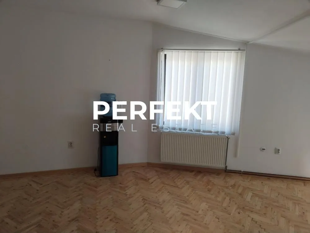 Empty room with hardwood flooring and a window.