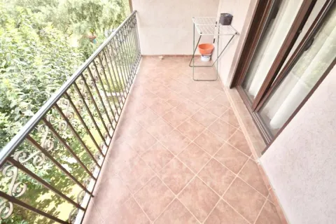 Small tiled balcony with metal railing and green views. - image 13