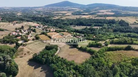 Pogled iz vazduha na prirodu i okolno naselje sa brdima u pozadini. - image 6