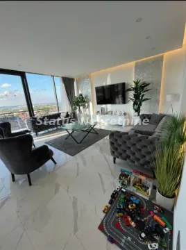 Spacious living room with a sofa set, large windows and a wall-mounted TV. - image 8