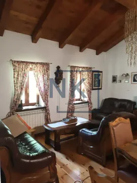 Dnevna soba sa kožnim garniturama, drvenim namještajem i krovom sa vidljivim gredama. - image 16