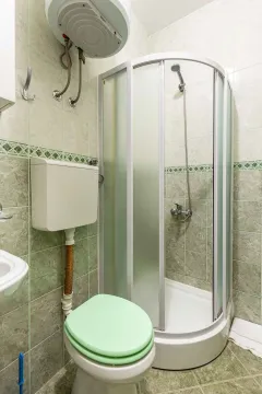 Kupatilo sa tuš kabinom, WC šoljom i bojlerom na zidu. - image 7
