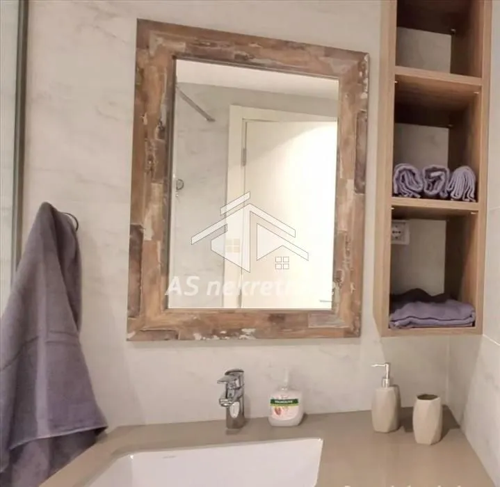 View of the washbasin with a mirror in the furnished bathroom.