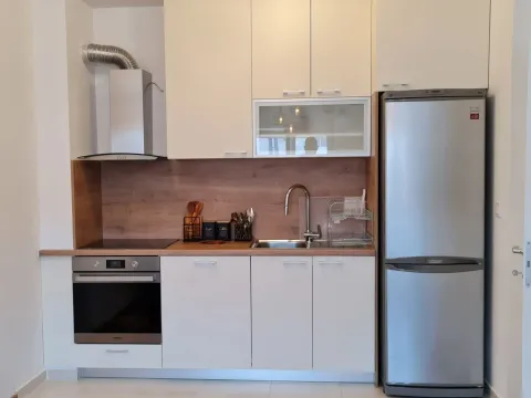 Bright kitchen with built-in appliances and a refrigerator. - image 12