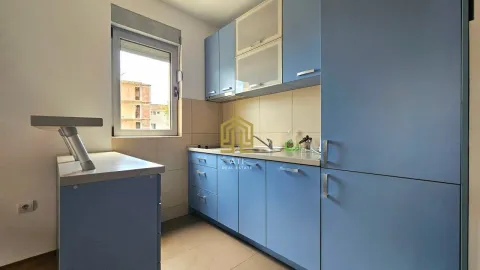 Small kitchen with blue cabinets and a window. - image 5