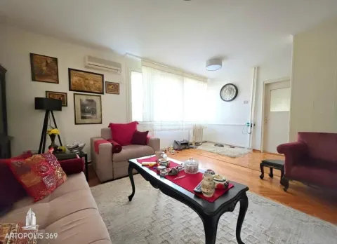 Dnevna soba sa garniturom, foteljama, stočićem i slikama na zidu. - image 2