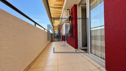 Dugačak popločani balkon sa metalnom ogradom i spoljnim jedinicama klima uređaja. - image 10