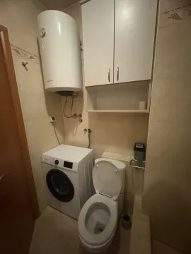 Manje kupatilo opremljeno toaletom, veš mašinom, bojlerom i zidnim elementom. - image 12