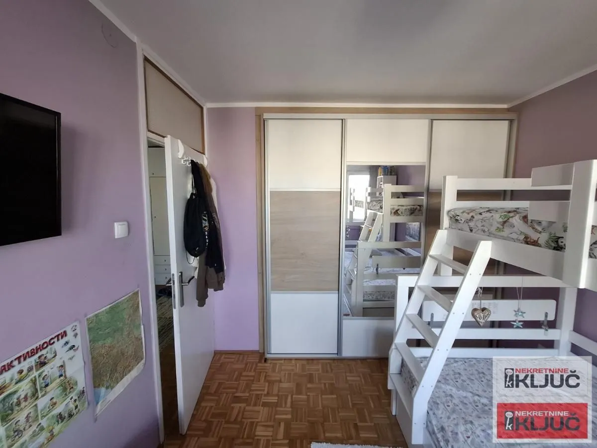 Dečja spavaća soba sa krevetom na sprat i garderoberom.