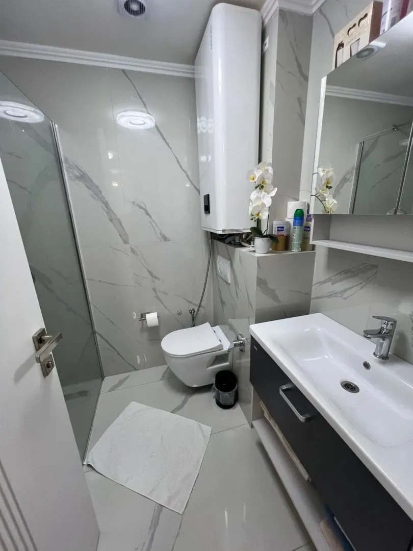 Moderne opremljeno kupatilo sa tuš kabinom, umivaonikom i wc šoljom.