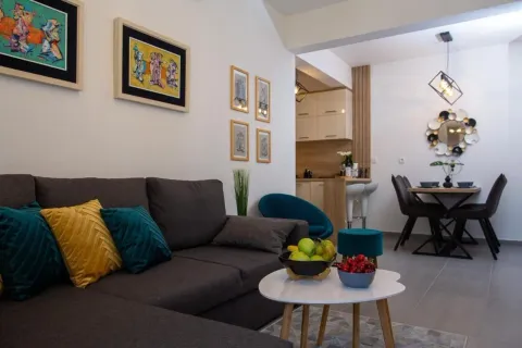 Living room with a sectional sofa, coffee table, and a view of the dining area and kitchen. - image 6
