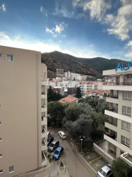 View from the terrace overlooking the urban neighborhood, surrounding buildings, and a hill. - image 8