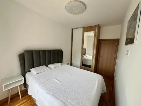 Spavaća soba sa bračnim krevetom, ormarom sa ogledalom i noćnim stočićem. - image 8