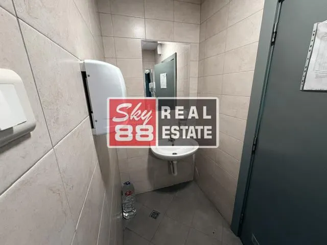 Small bathroom with a washbasin, mirror, and soap dispenser.