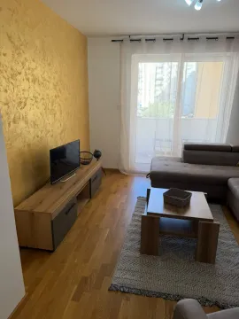 Living room with a sectional sofa, TV unit, and a decorative gold wall. - image 9