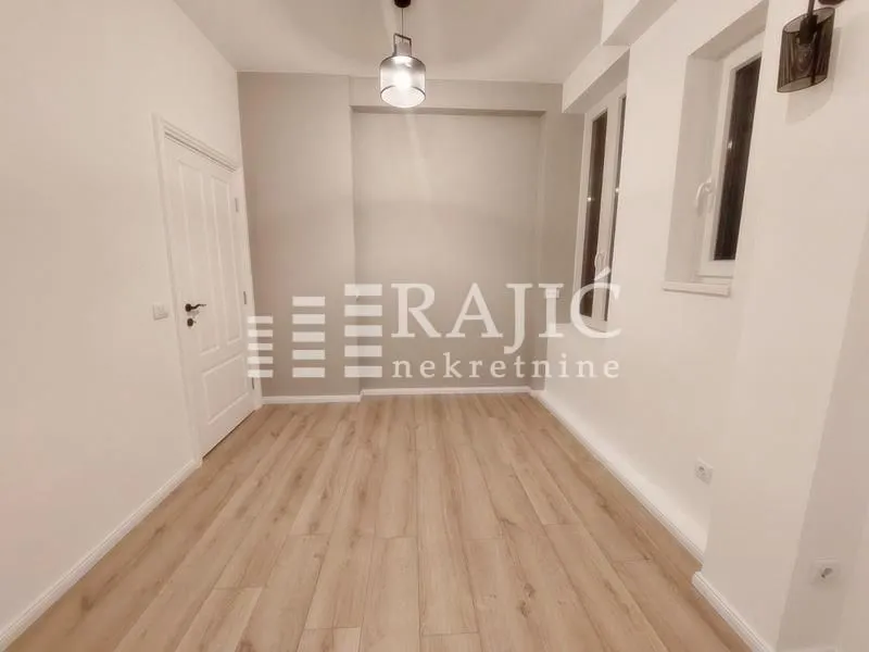 Empty room with laminate flooring and white door.
