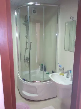 Small bathroom with a shower cabin and a washbasin. - image 10