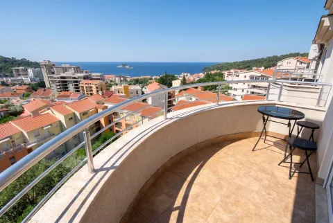 Curved balcony with a table and chairs and a sea view. - image 6
