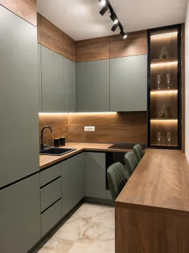 Modern kitchen with green fronts and wooden details. - image 3
