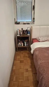 Spavaća soba sa krevetom, noćnim ormarićem i prozorom sa roletnama. - image 7