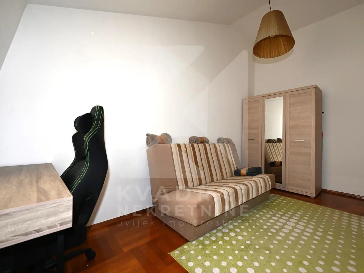 Smaller bedroom with a bed, wardrobe, and desk.