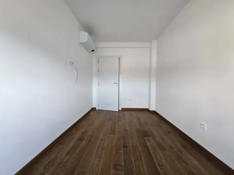 Empty room with white walls, wooden flooring, and an air conditioner. - image 16