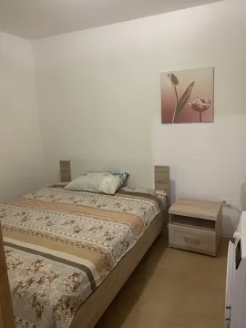 A bright bedroom featuring a double bed and a wooden nightstand. - image 7