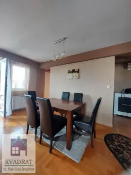 Dining area with a wooden table and black chairs in an apartment with parquet flooring. - image 3