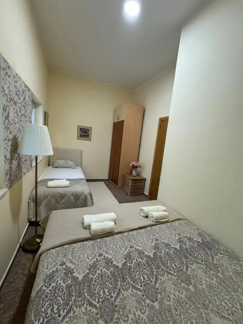 Uređena spavaća soba sa dva kreveta i peškirima.