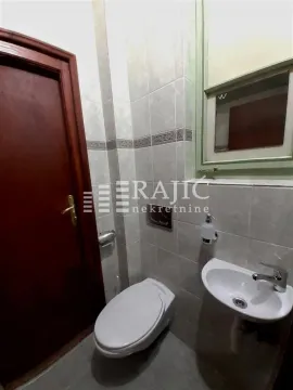 Small bathroom with toilet, washbasin, and wooden door. - image 14
