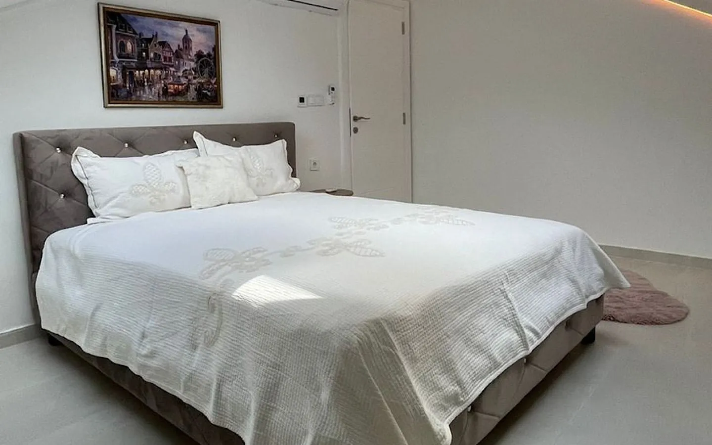 Spacious bedroom with a large double bed and white bedding.