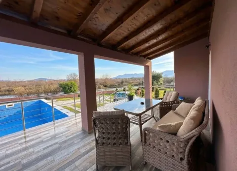 Covered terrace with seating furniture and a view of the pool and nature. - image 2