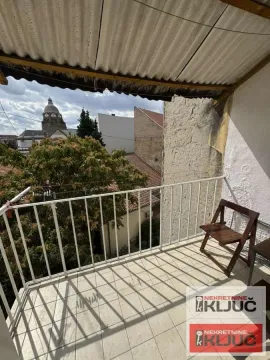 Natkriveni balkon sa pogledom na grad i okolne zgrade. - image 5