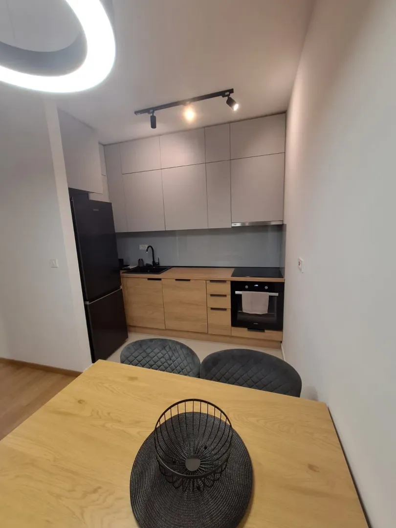 Modern kitchen with a dining table and grey cabinets.