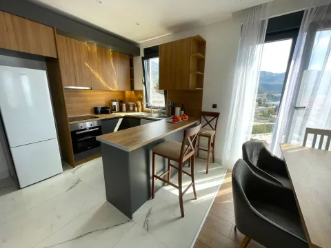 Modern kitchen with a breakfast bar and a dining area by the window. - image 16
