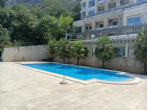 Spoljašnji prostor sa bazenom i palmama ispred zgrade. - image 3