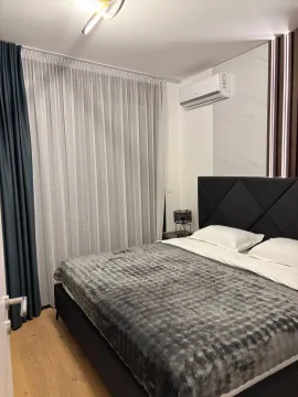 Modern bedroom with a double bed and a window with curtains. - image 7