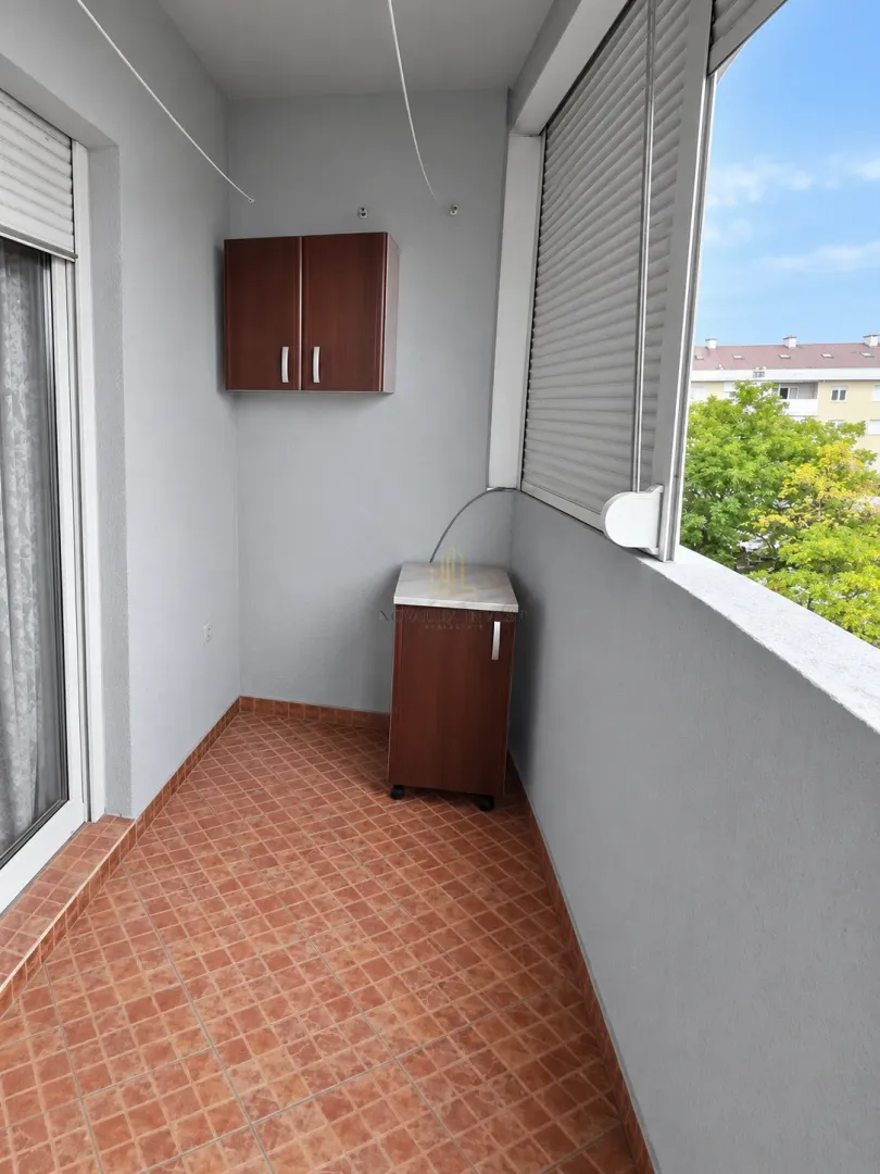 Covered balcony with tiled flooring and small storage cabinets.