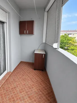 Covered balcony with tiled flooring and small storage cabinets. - image 9