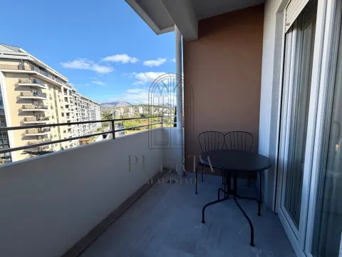 Small covered terrace with a table and chairs and a city view. - image 4